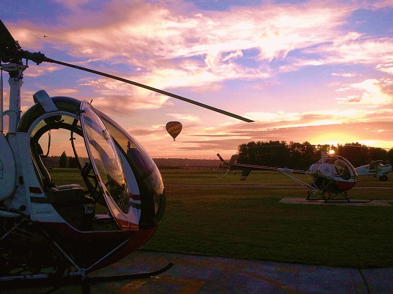 Helicopter and balloon at sunset